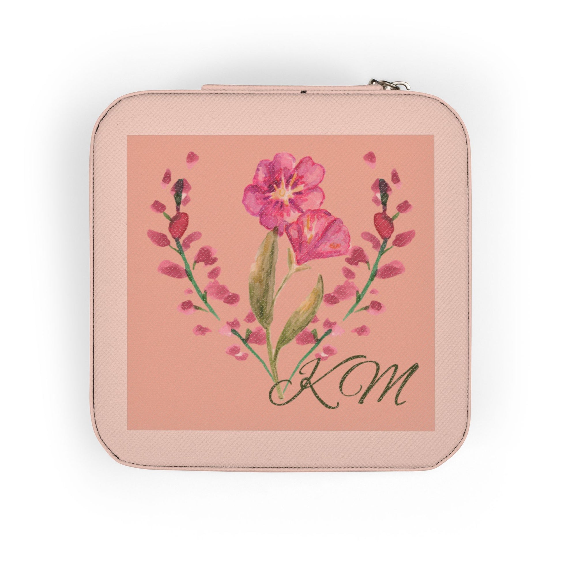 A square zippered pouch in a light pink textured material, featuring a central square print with a pink flower illustration and the initials 'KM' in black script.