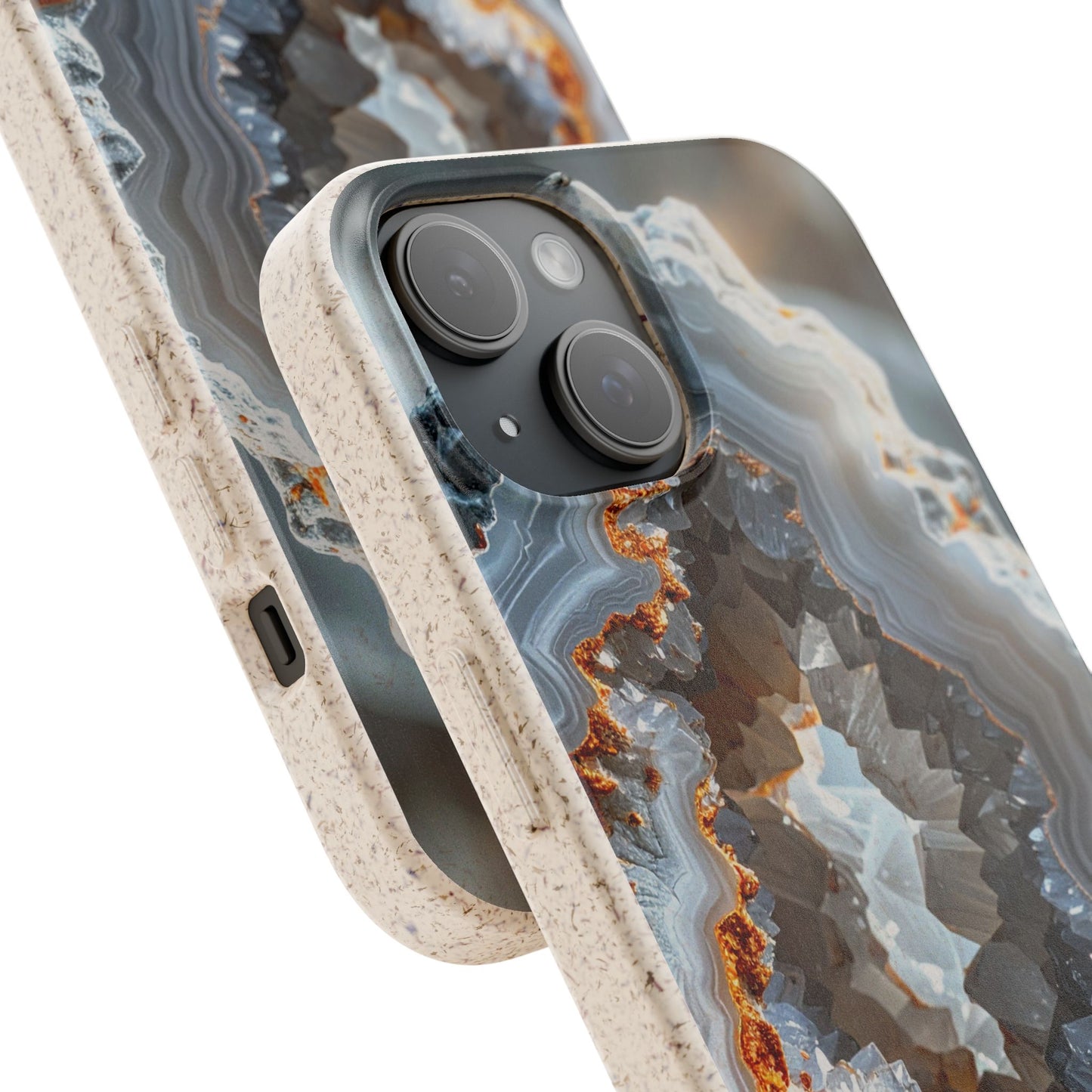 Close-up of a smartphone case with a geode or agate-inspired pattern in gray, blue, white, and rust-orange tones, with a speckled beige bumper edge. No person, animal, or real environment is present.