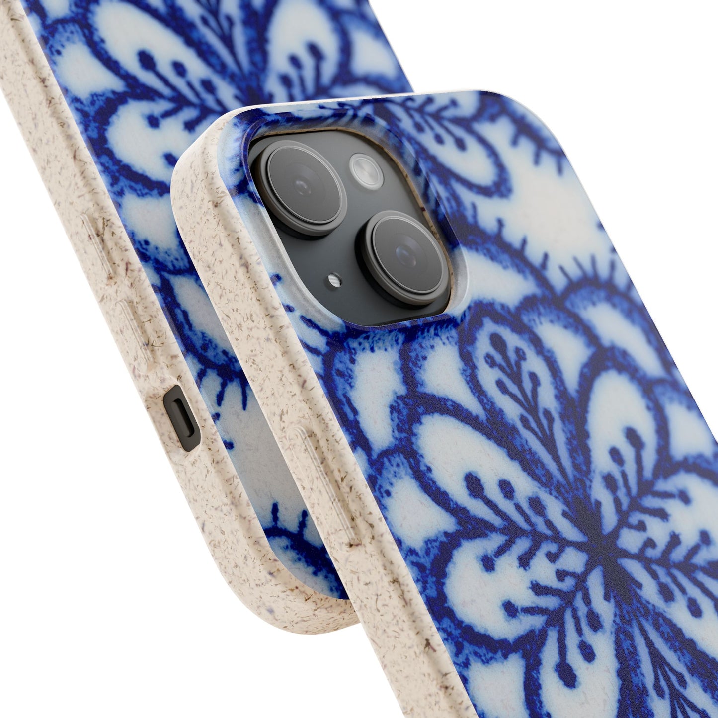 A close-up of a smartphone case with a blue floral mandala pattern on a white background, featuring a textured beige side bumper and a black camera cutout.