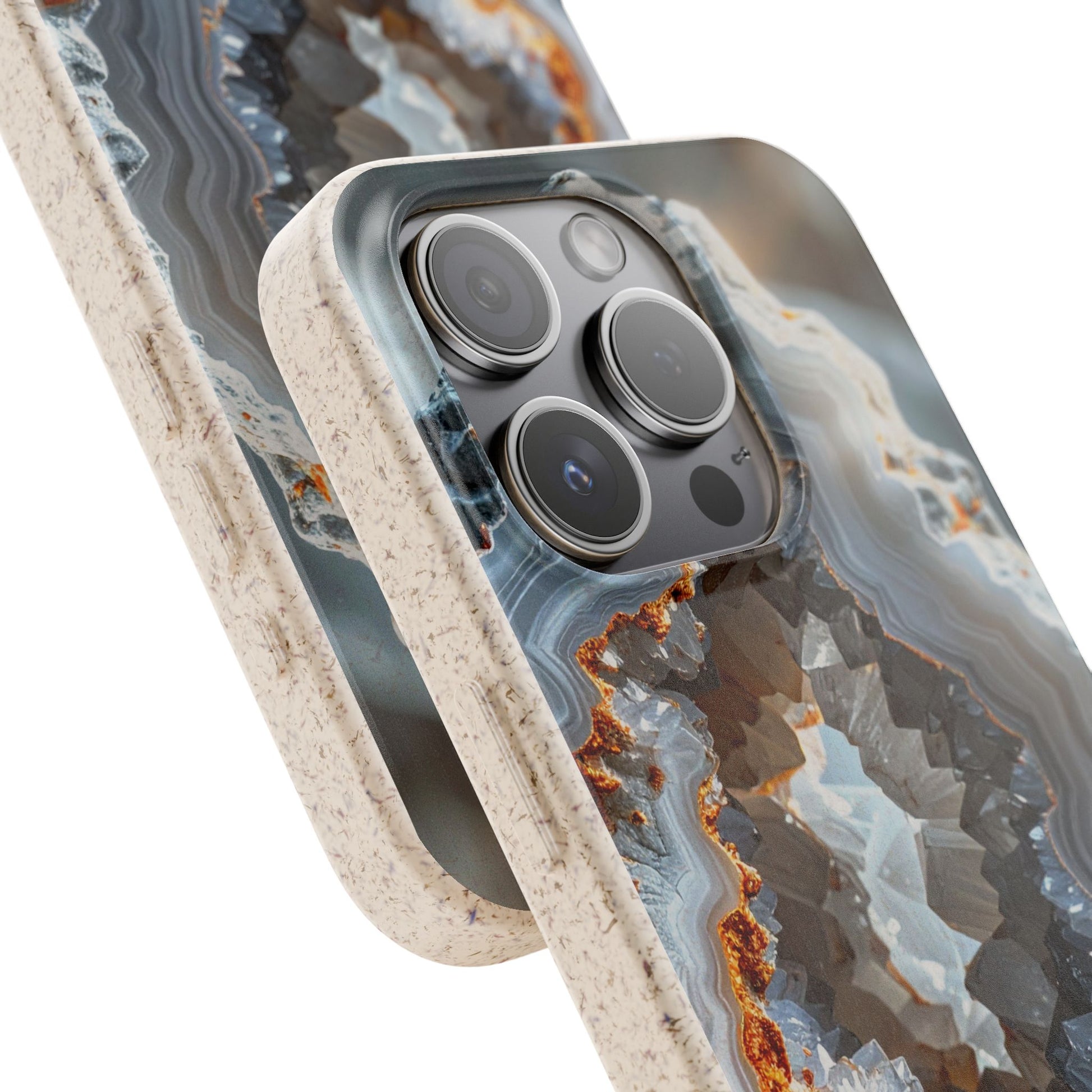 A close-up of a smartphone case with a geode or agate-style pattern in gray, blue, white, and rust-orange tones, with a speckled beige border. The phone camera cutout is visible, and the case is shown on a clean white background.