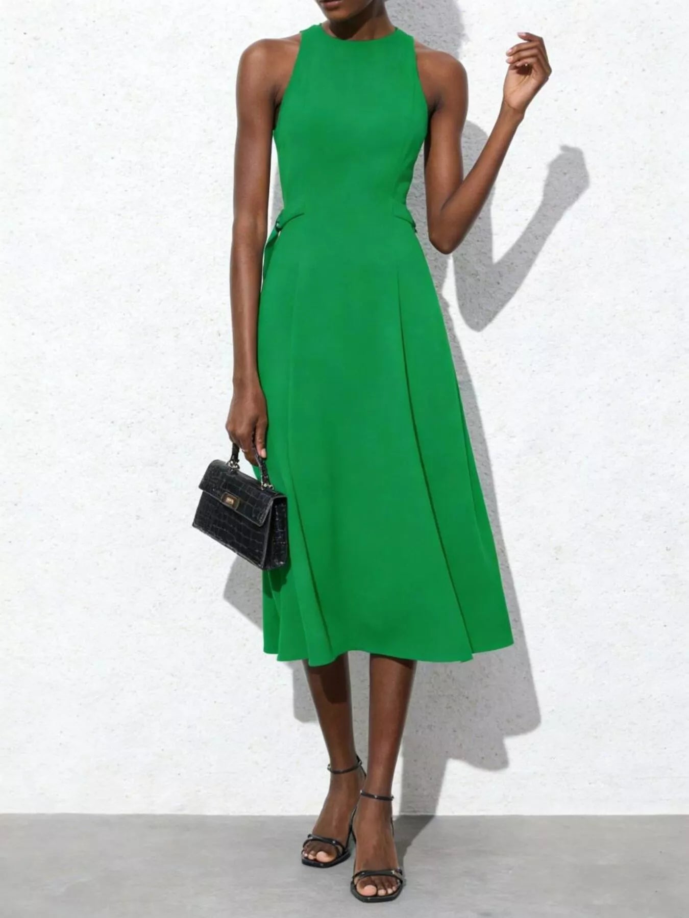 Green dress worn by a model against a white background