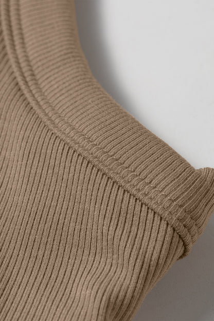 Close-up of a tan ribbed fabric tank top showing the shoulder seam and textured vertical lines.