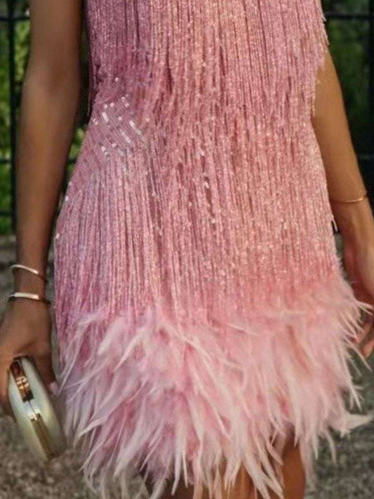 Close-up of a pink dress with feather details and a blurred background