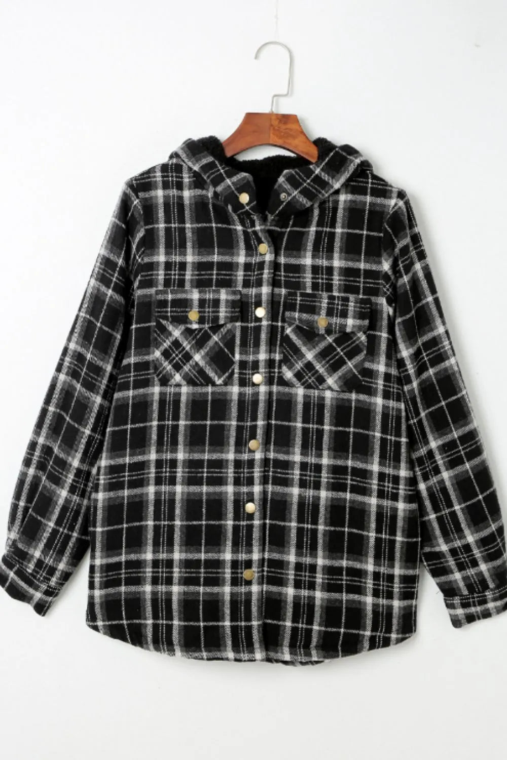 Black and white plaid shirt on a hanger against a white background