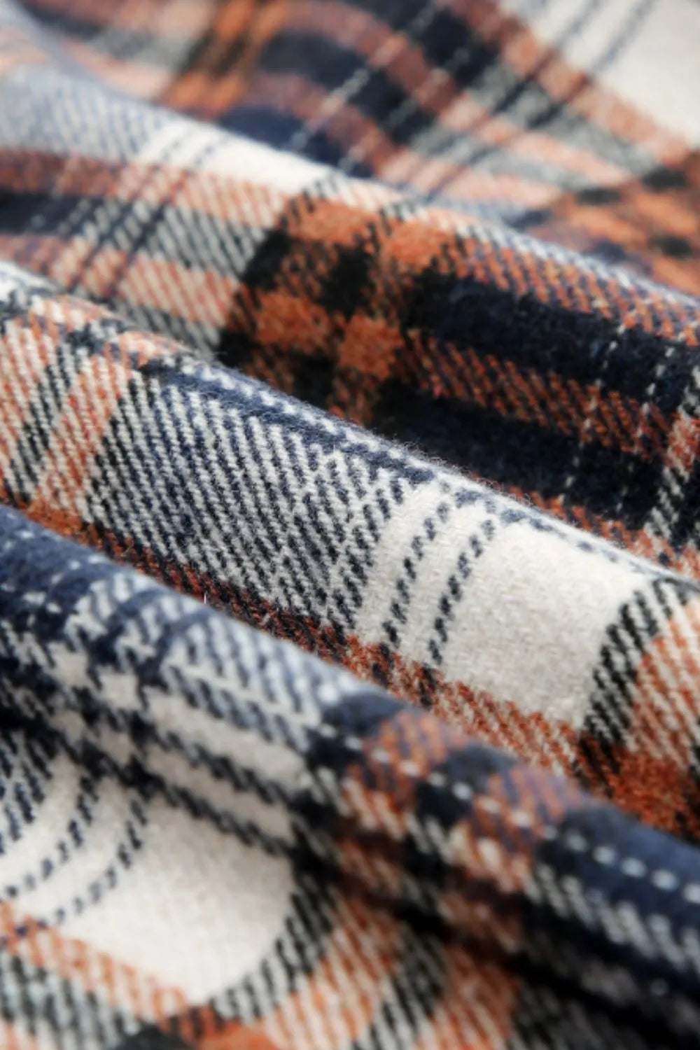 Close up of blue brown, cream, and black plaid fabric.