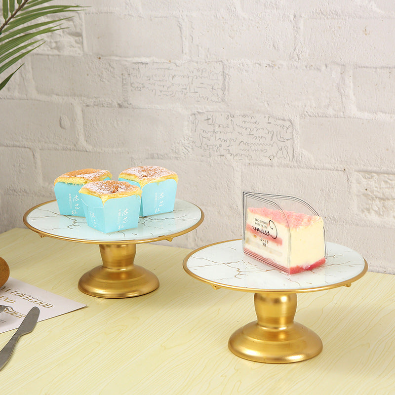 Marble cake stand displaying cakes.