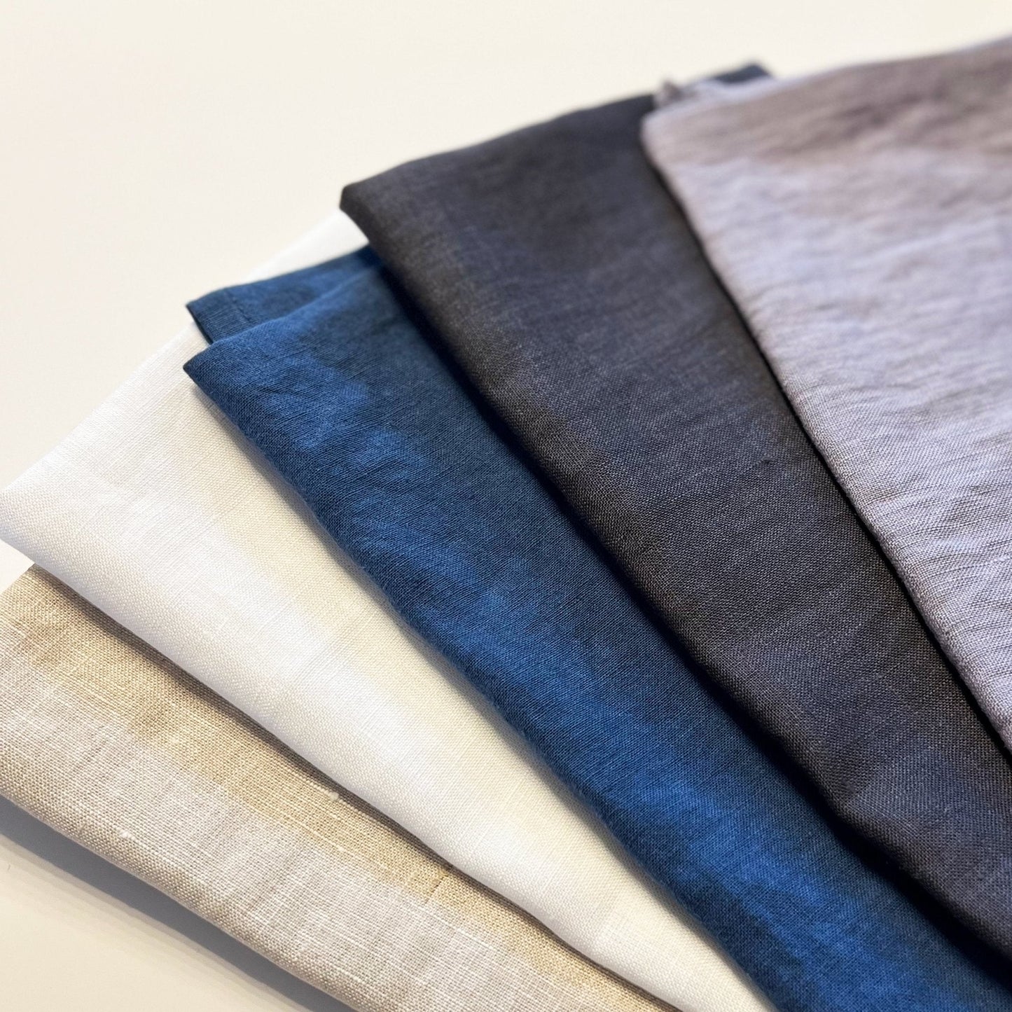 Five different fabric swatches in various colors on a light background