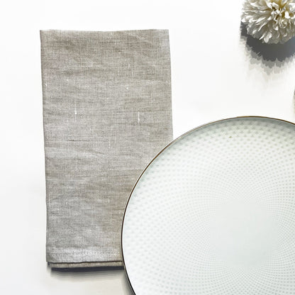 Gray textured napkin on a white surface with a textured plate
