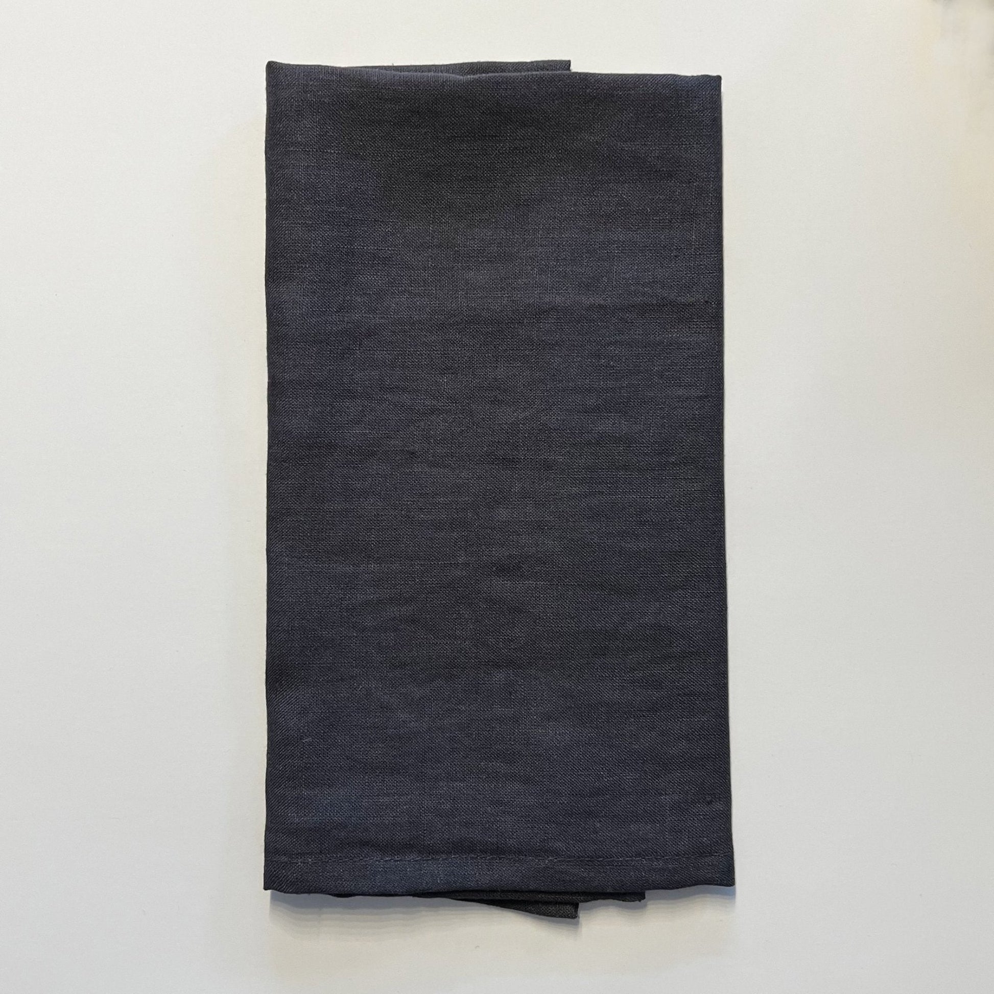 Dark gray napkin folded on a white background