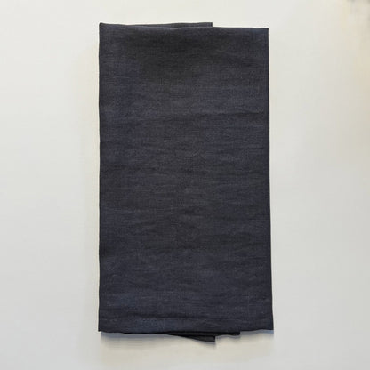 Dark gray napkin folded on a white background
