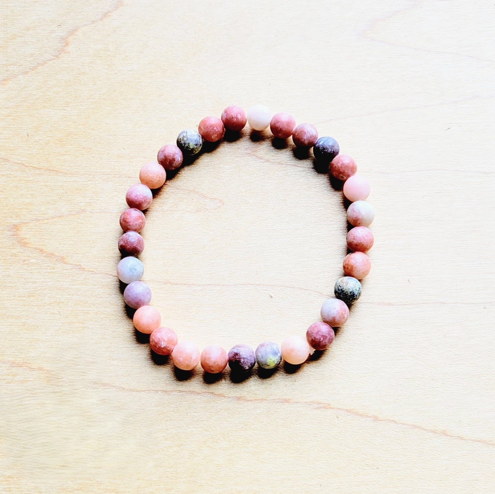 Multicolored beaded bracelet on a light wooden surface