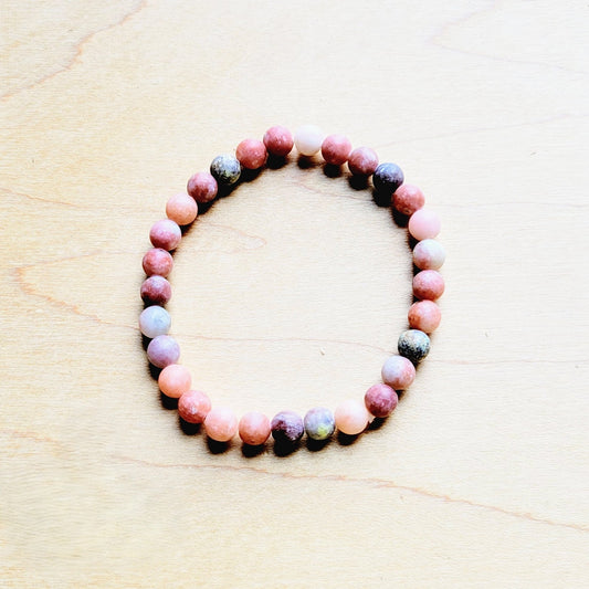 Multicolored beaded bracelet on a light wooden surface