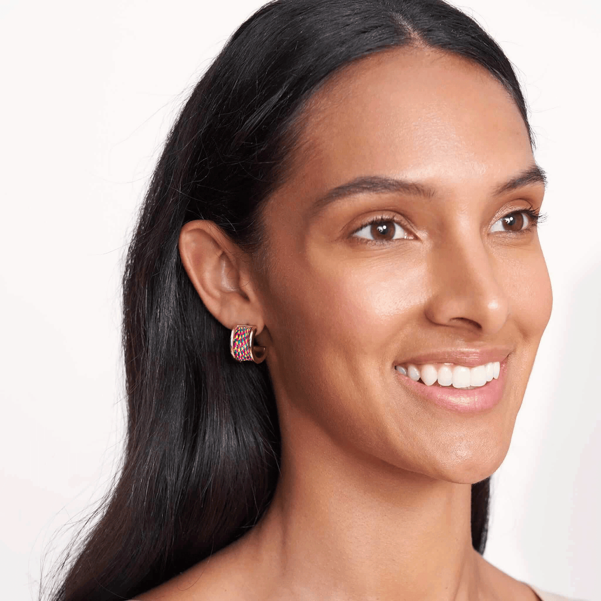 Woman wearing earrings with a plain background