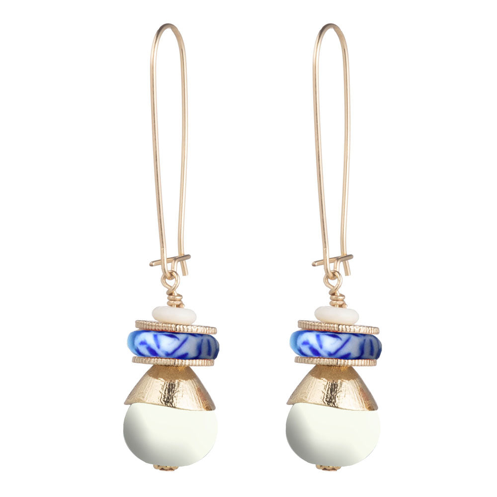 A pair of gold-tone drop earrings featuring a small white bead, a blue and white patterned round bead, a textured gold cone, and a large smooth white oval bead at the bottom, shown on a plain white background.