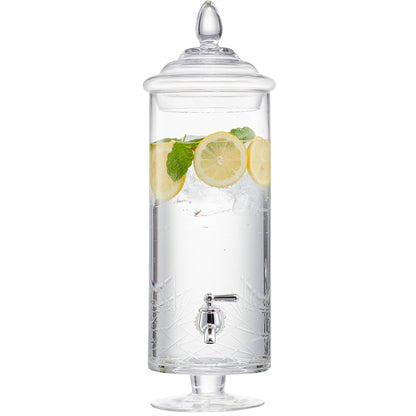 Tall cylindrical glass beverage dispenser with a metal spigot, lid, and lemon slices inside.