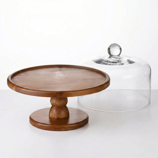 Round brown wood pedestal cake stand next to a clear glass dome with a round handle on a white surface.