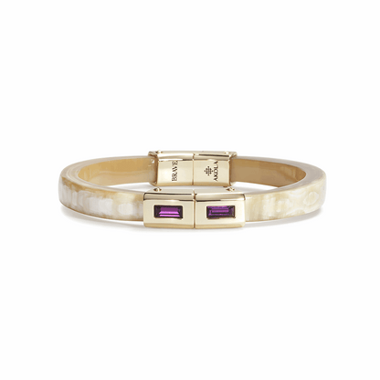 Gold bracelet with purple gemstones on a white background