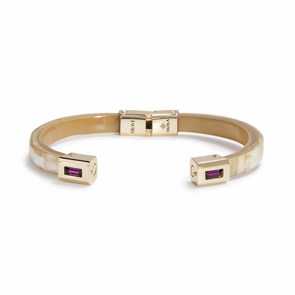 Gold bracelet with purple gemstones on a white background