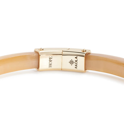 Gold bracelet with a clasp on a white background