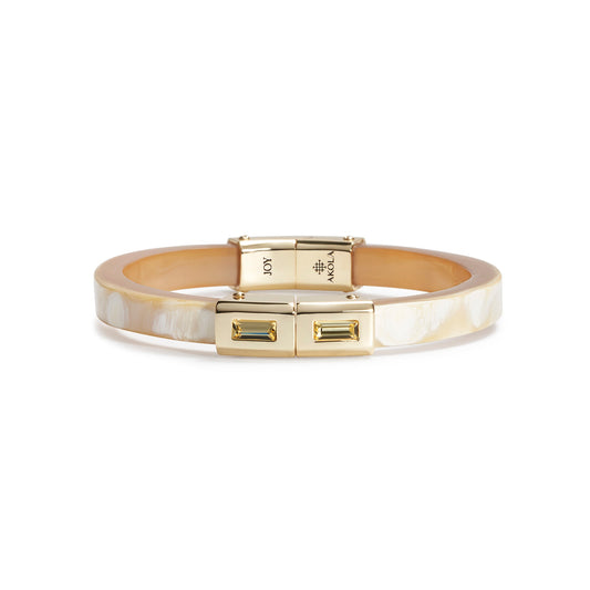 Gold bracelet with a visible brand logo on a white background