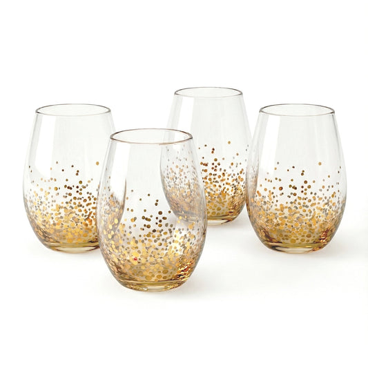 Four clear glass stemless wine glasses with gold luster confetti dots around the base, arranged on a white surface.