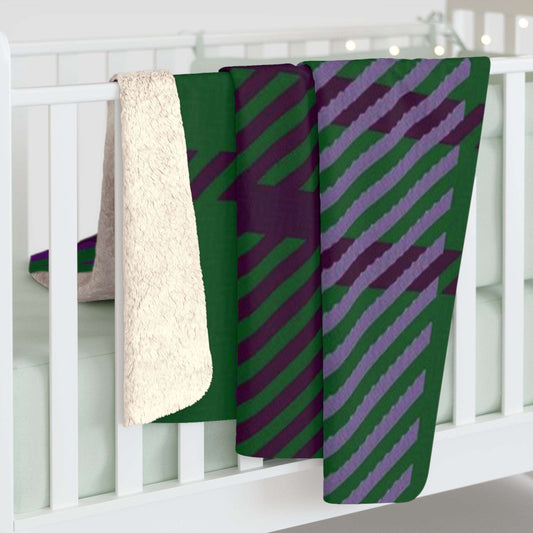 A folded baby blanket draped over a white crib, showing a green and purple diagonal striped pattern on one side and a soft cream sherpa fleece backing on the other.