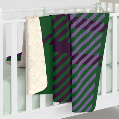 A folded baby blanket draped over a white crib, showing a green and purple diagonal striped pattern on one side and a soft cream sherpa fleece backing on the other.