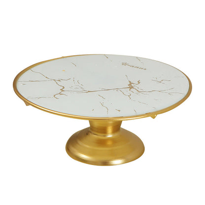 Round marble cake stand with gold base on a white background