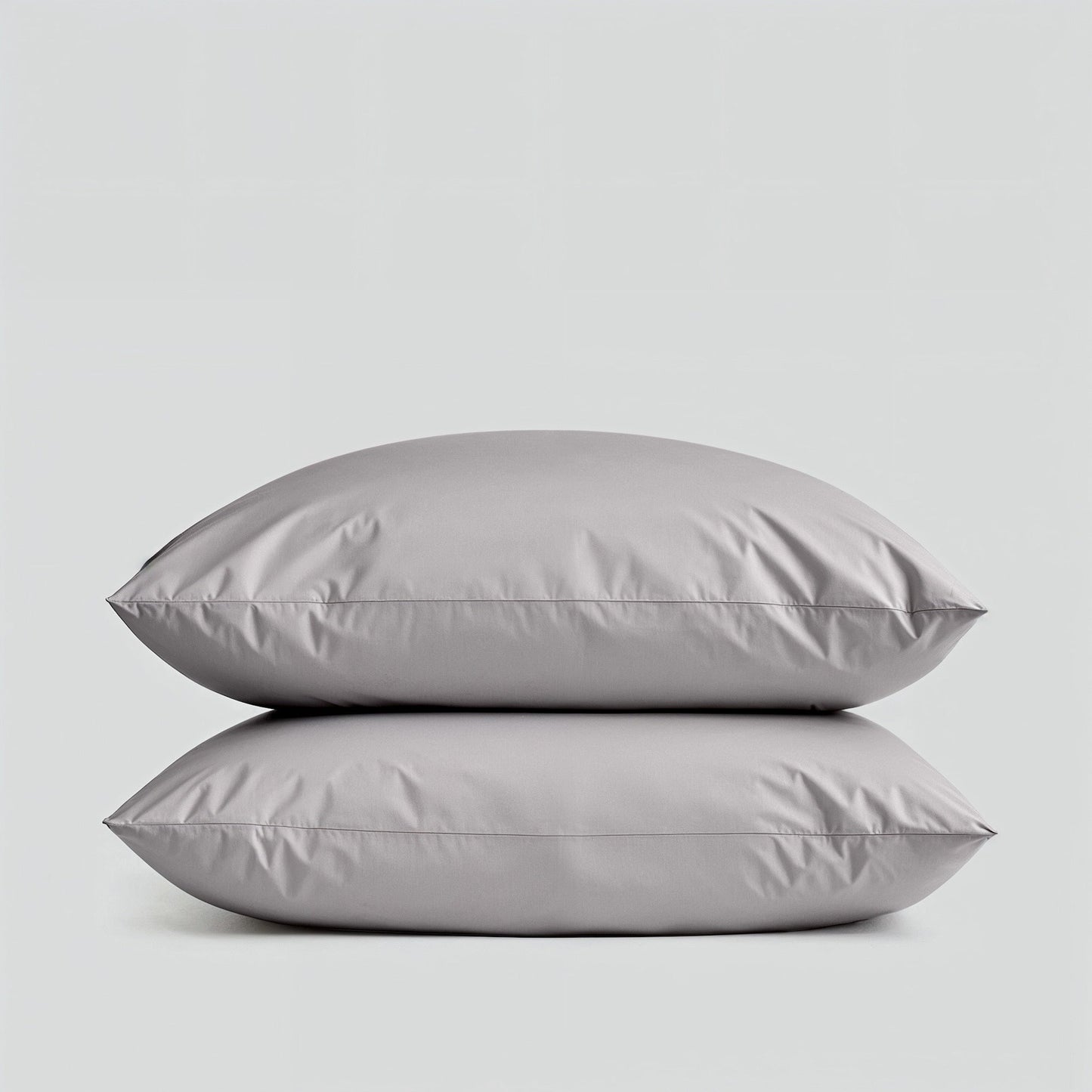 Two gray pillows stacked on a light gray background
