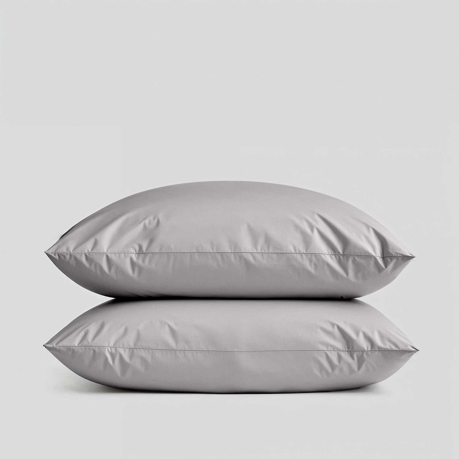 Two gray pillows stacked on a light gray background