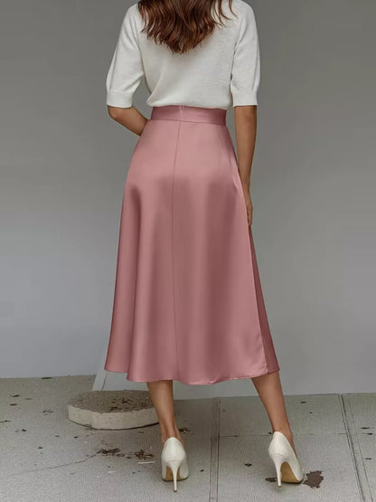 Person wearing a white top and pink satin skirt on a plain background
