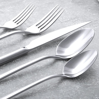 Set of silver forks and spoons on a gray surface
