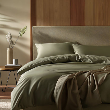 Neatly made bed with green bedding in a bedroom setting.