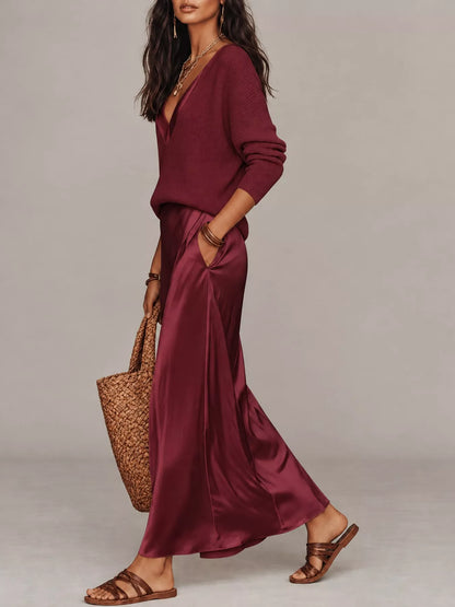 Side view of burgundy V-neck top and satin midi skirt, showing the side pocket.