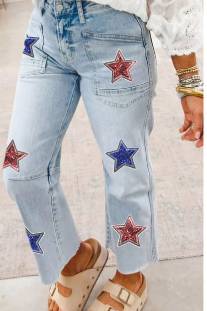 Light blue jeans with star patches worn by a person on a light background
