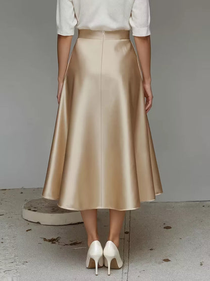Person wearing a gold skirt and white shoes on a plain background
