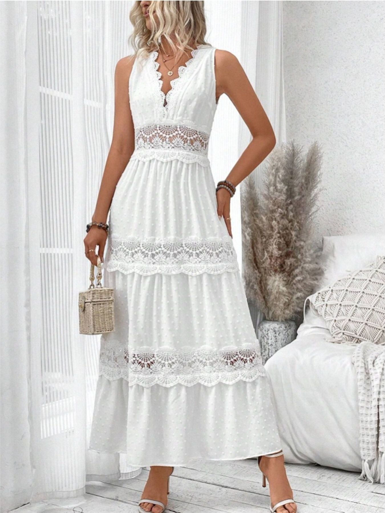 Woman wearing a white lace dress in a bright room.