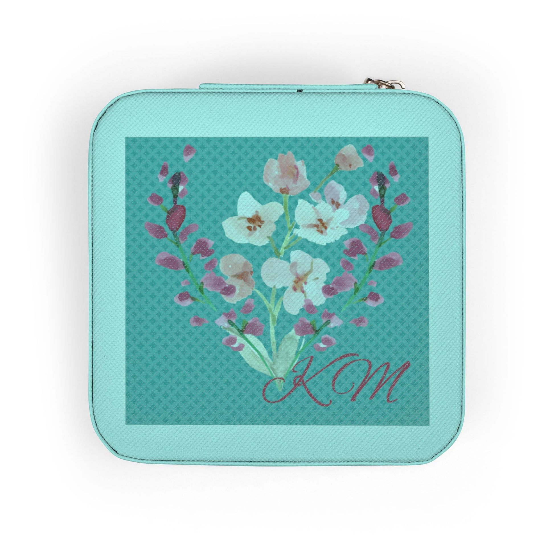 A square zippered pouch in mint green with a central floral print featuring white and pink blossoms on a teal patterned background, with the initials 'KM' in cursive at the bottom.