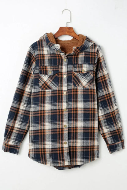 Plaid shirt on a hanger against a white background