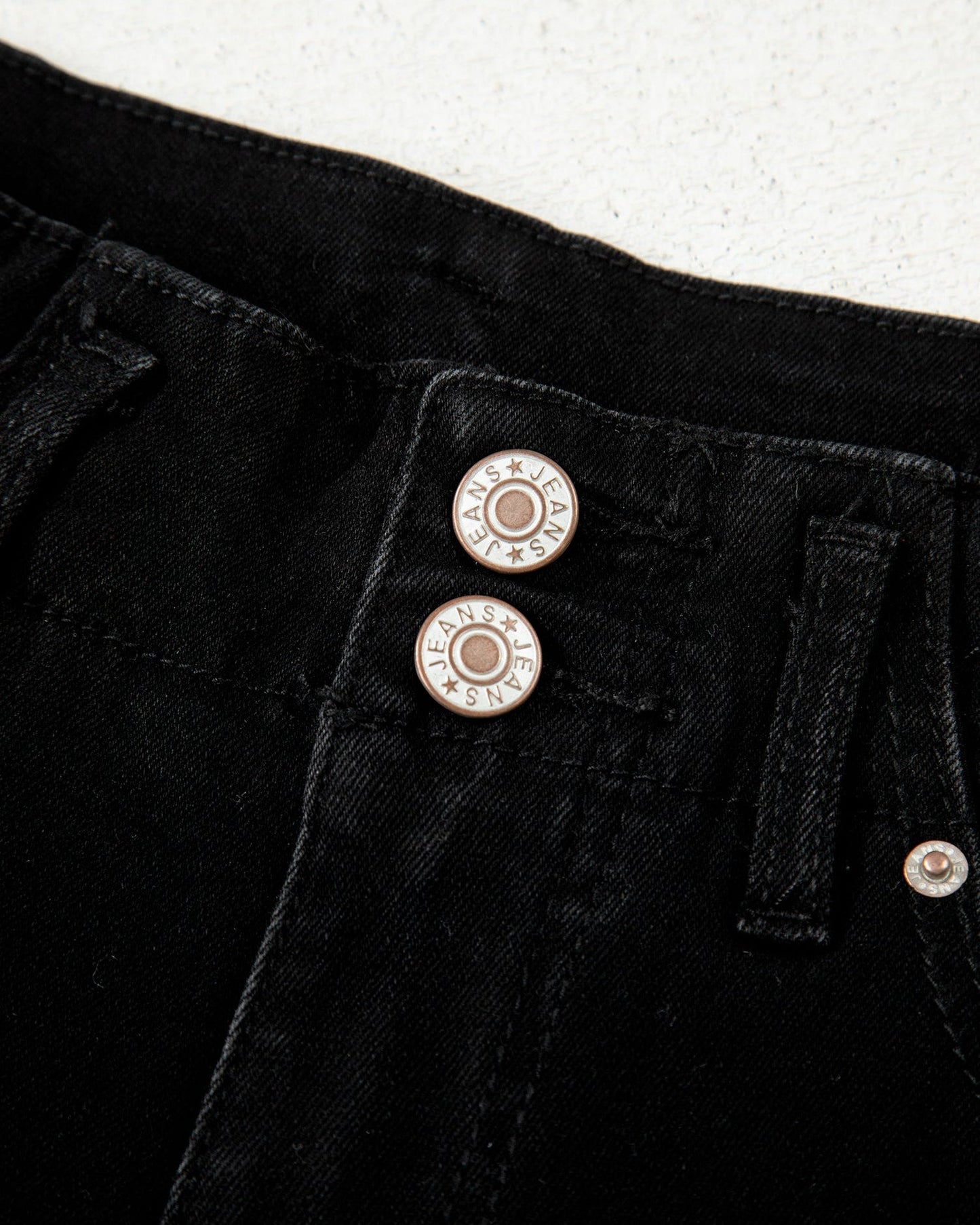 Close-up of black pants with buttons on a white background