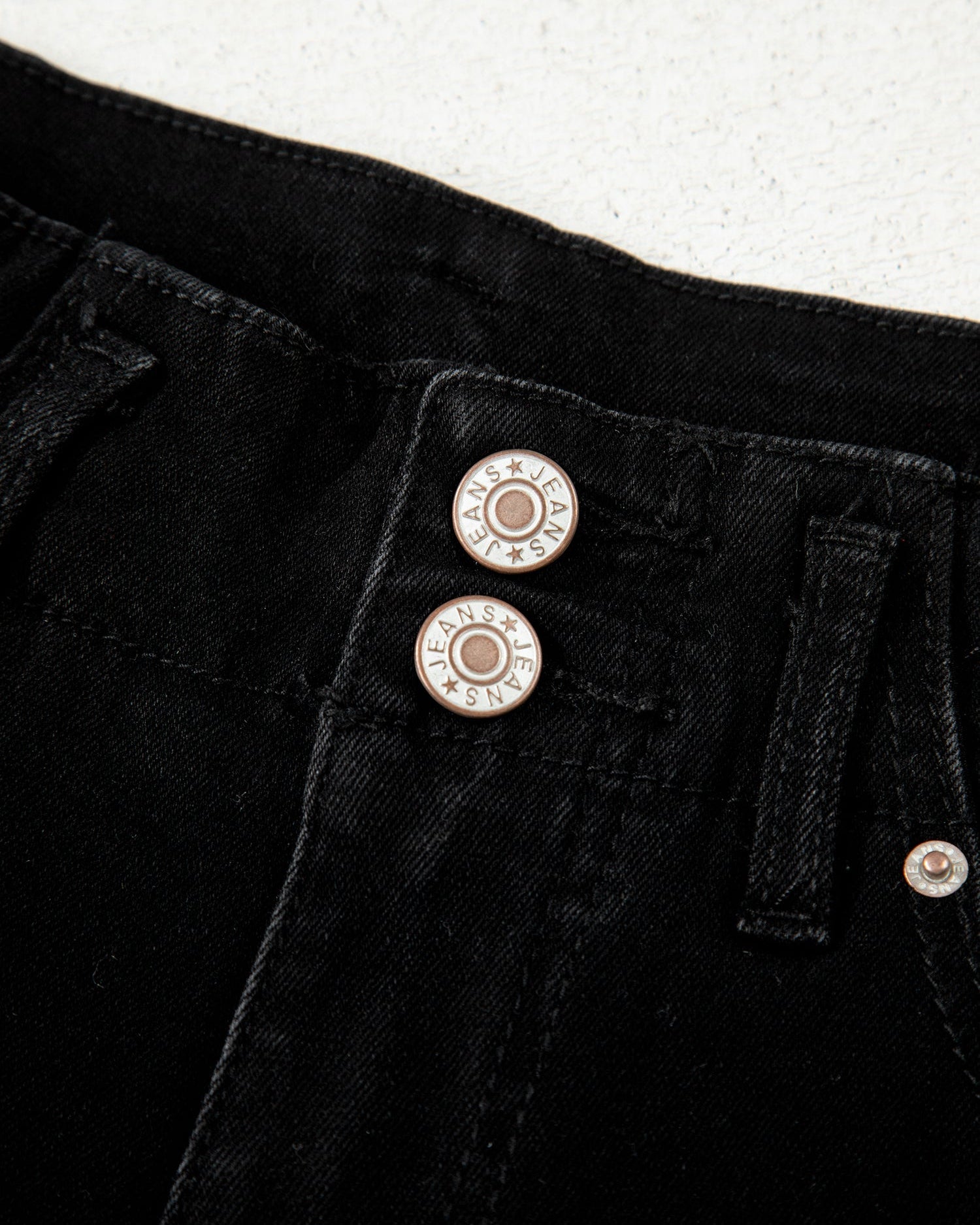 Close-up of black pants with buttons on a white background