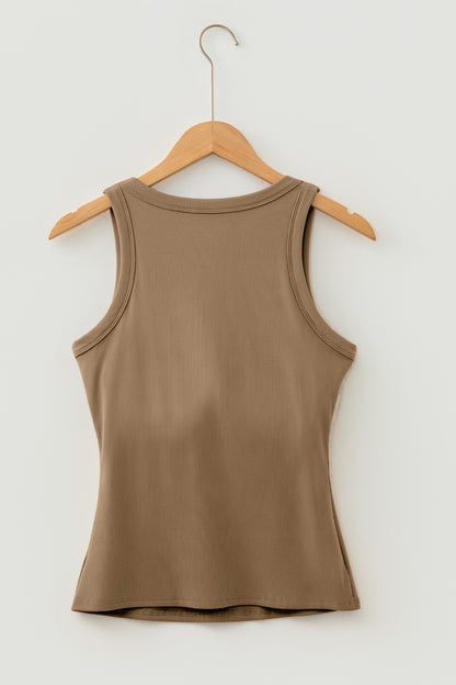 Brown ribbed fabric tank top hanging on a wooden hanger against a white wall.