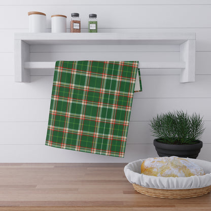 Gray towel with shark pattern hanging on a white wall above a wooden shelf.