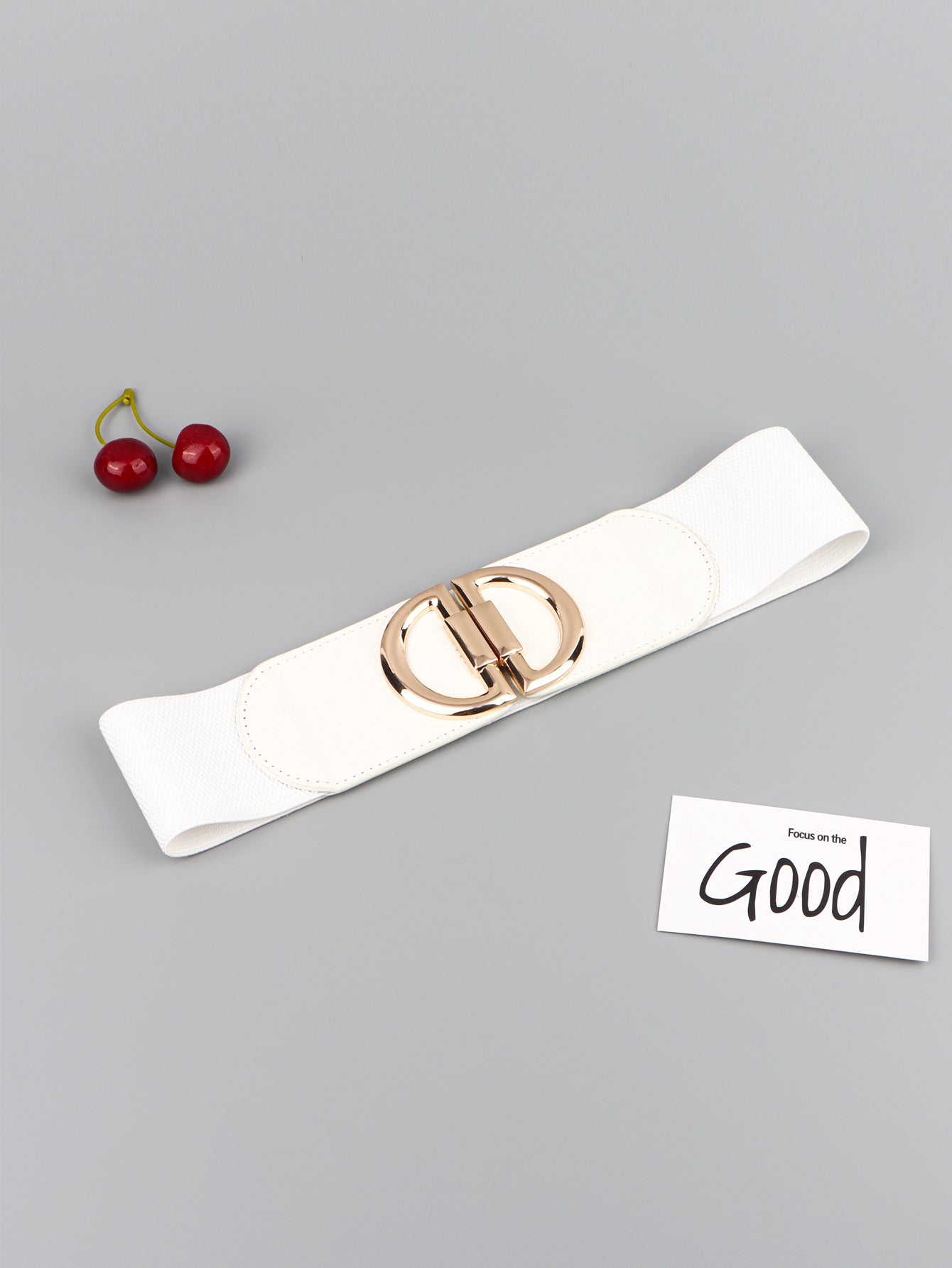 White belt with a gold buckle on a gray background