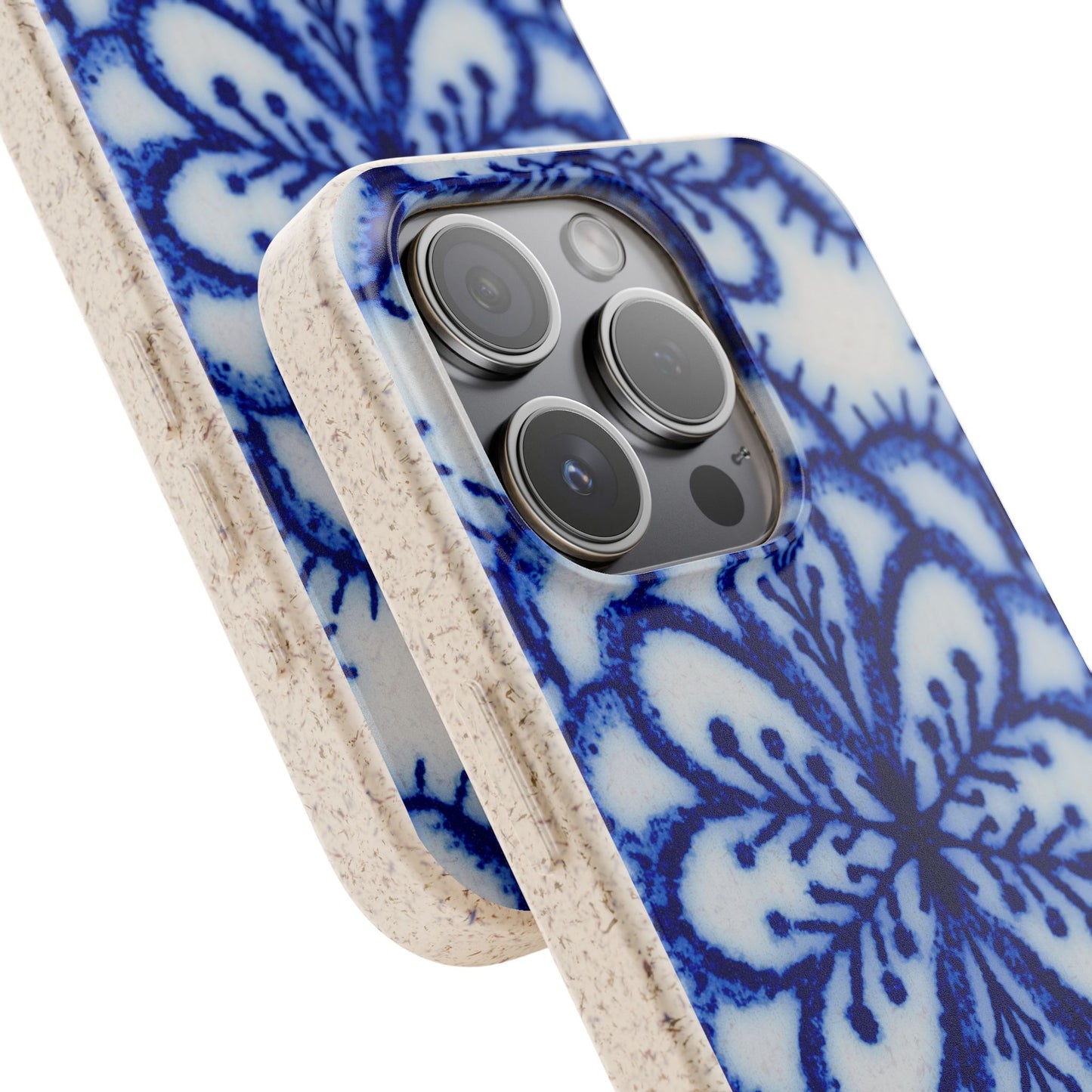 A close-up of a smartphone case with a blue floral or damask-style pattern on a white base, with a textured beige side bumper and edge. The case is shown fitted on a phone against a plain white background.