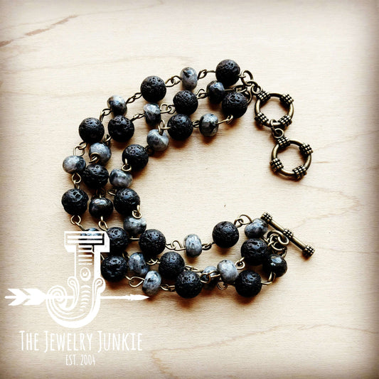 Necklace with black and gray beads on a wooden surface, branded 'The Jewelry Junkie'.