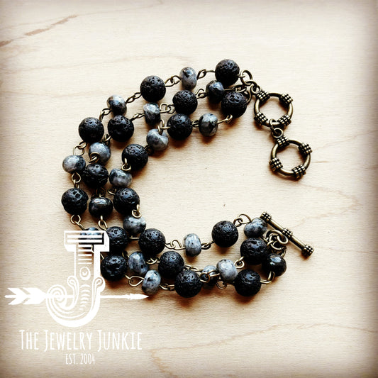 Necklace with black and gray beads on a wooden surface, branded 'The Jewelry Junkie'.