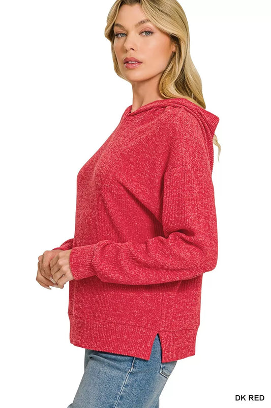 A woman wearing a heathered red pullover hoodie with a relaxed fit, paired with blue jeans, shown from a side profile against a white background.