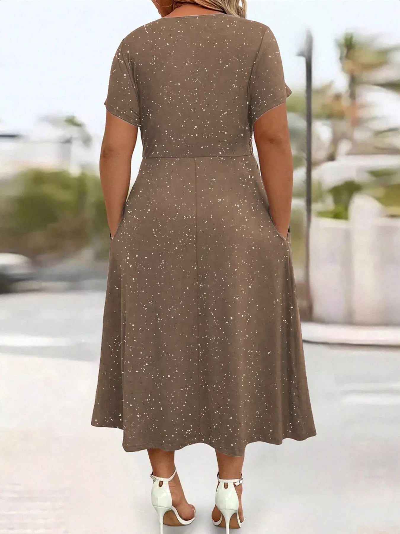 Woman wearing a brown dress with a blurred outdoor background