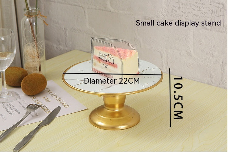 Gold cake display stand with measurements on a table